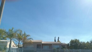 A residential area with houses, a white picket fence, and a clear blue sky. - H&L Self-catering Accommodation (Bonnievale)