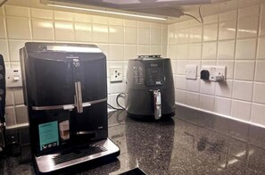 Eine Küche mit Kaffeemaschine, Wasserkocher und Mikrowelle.