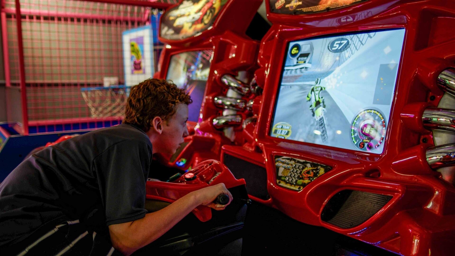 Iemand speelt een racegame op een rode spelcomputer.