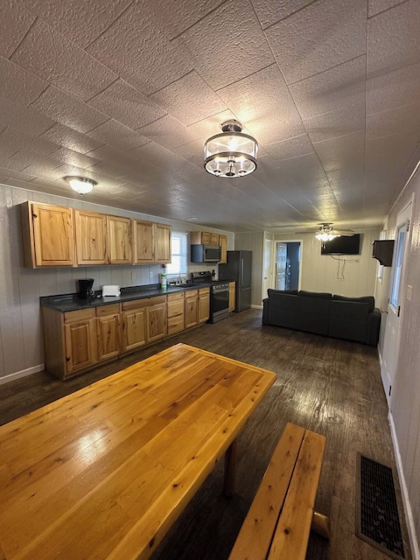 A spacious kitchen with wooden cabinets, a dining table, and a built-in oven.