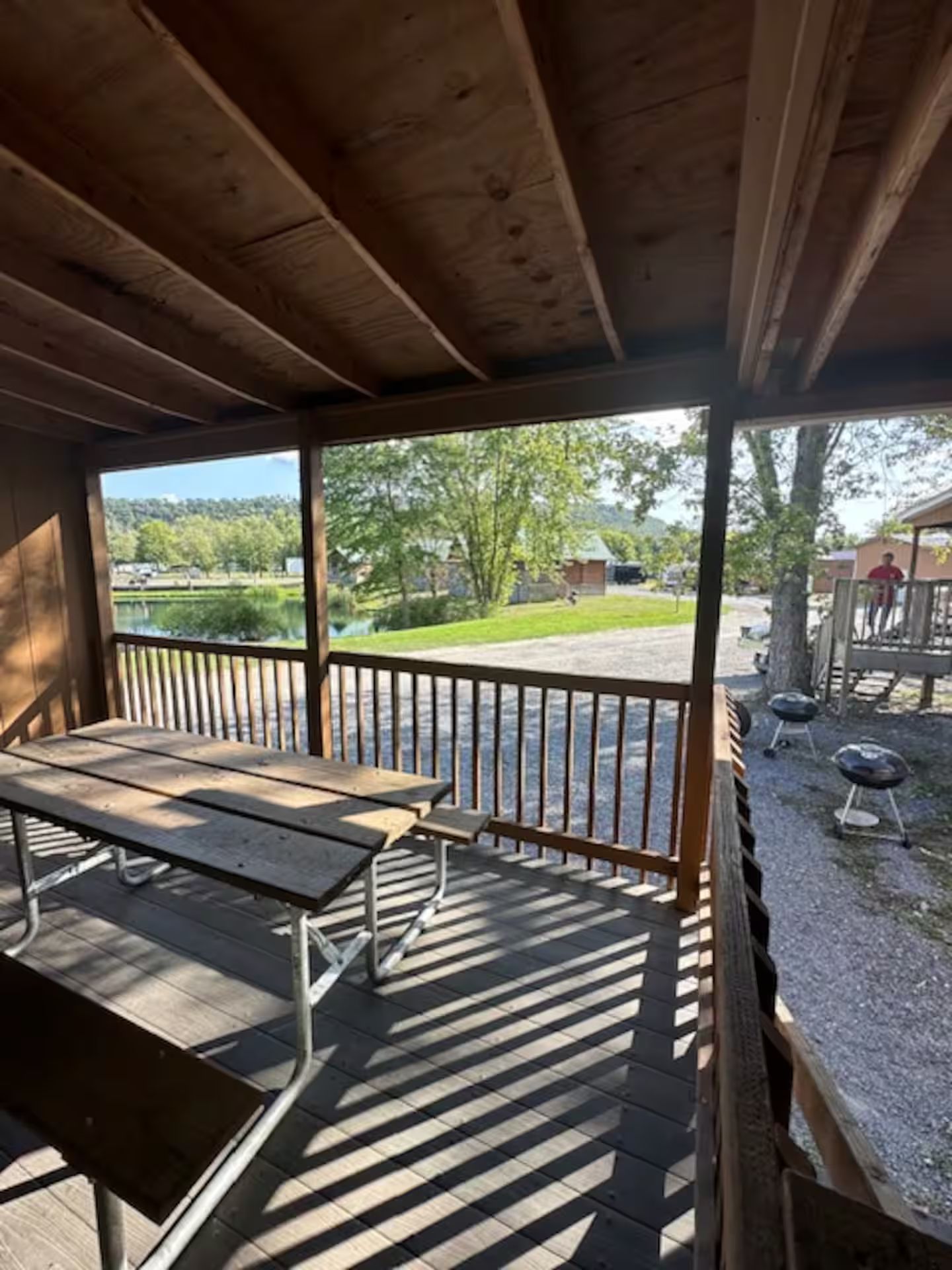 Un espace extérieur abrité, équipé d’une table de pique-nique et d’un barbecue.