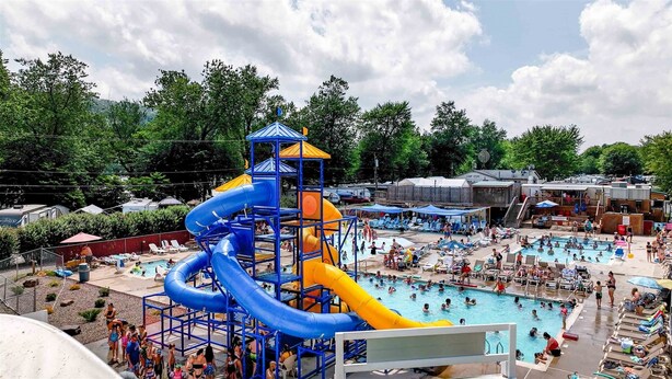 A water park with multiple slides and a swimming pool. - Splash Magic RV Resort (Northumberland)