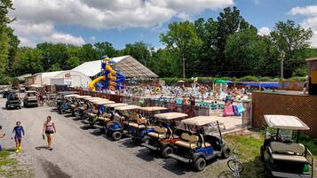 A parking lot with golf carts lined up, a water park with slides, and a crowd of people.