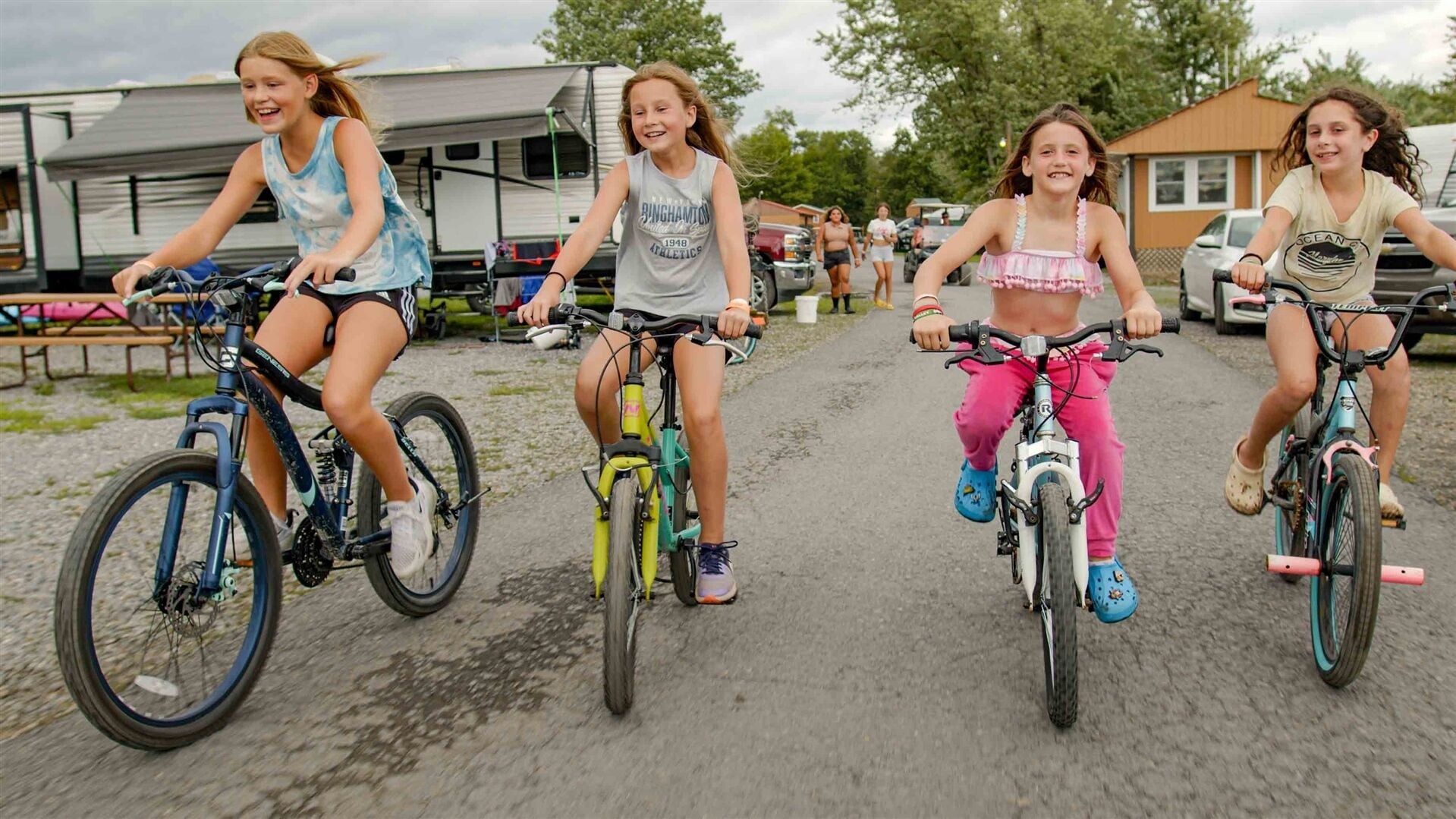 Three children riding bicycles on a paved path.