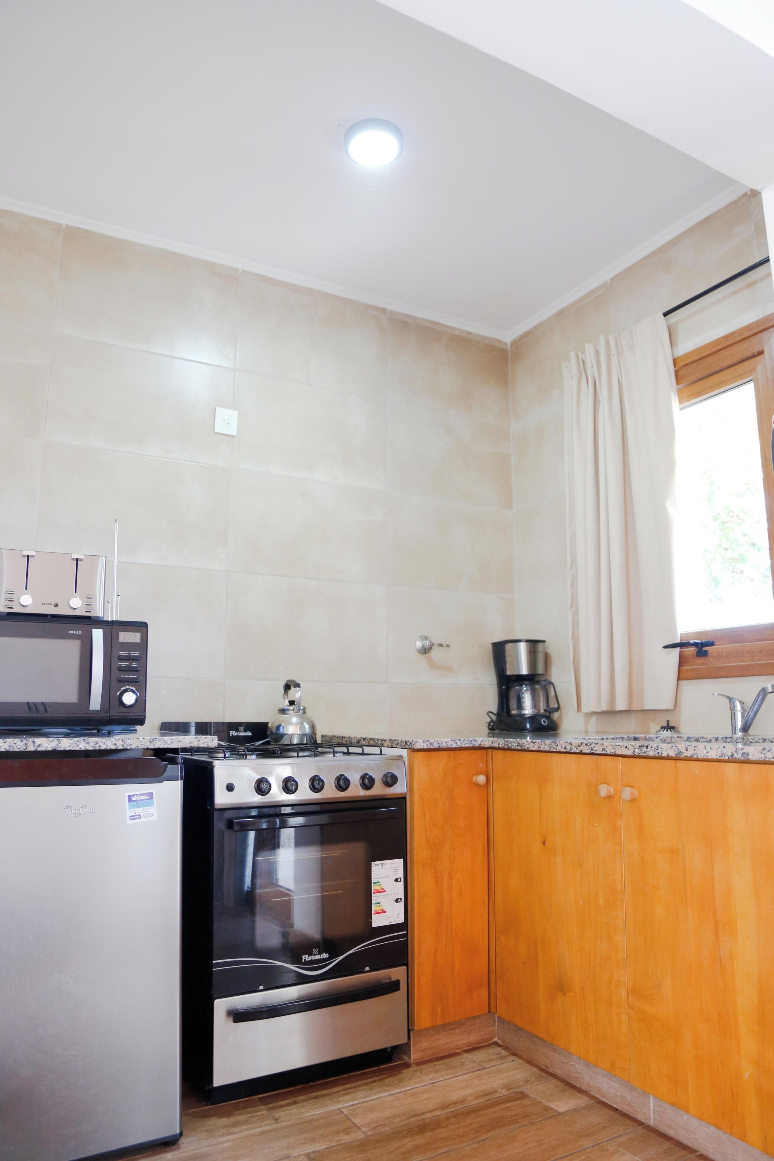 Una cocina equipada con microondas, estufa, horno y cafetera.