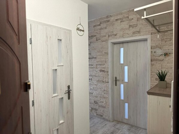 Un pasillo con dos puertas, una con un panel de vidrio esmerilado y otra con detalles de madera.