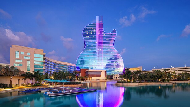 A hotel with a guitar-shaped building, a pool, and palm trees. - Luxury Fort Lauderdale Waterfront Home • Heated Pool • Game Room •  Park (Fort Lauderdale)