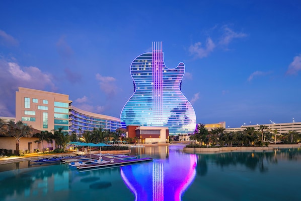 A hotel with a guitar-shaped building, a pool, and palm trees. - Luxury Fort Lauderdale Waterfront Home • Heated Pool • Game Room •  Park (Fort Lauderdale)