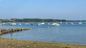 A marina with boats docked, a wooden pier, and a distant forested hill. - Le Minihic sur Rance - Charming house with its cat Platon between land and sea (Le Minihic-sur-Rance)