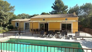 A yellow building with a swimming pool, outdoor seating, and a fenced patio area. - Villa in a residential neighborhood in Uzès (Uzès)