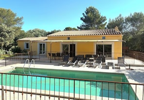 A yellow building with a swimming pool, outdoor seating, and a fenced patio area. - Villa in a residential neighborhood in Uzès (Uzès)