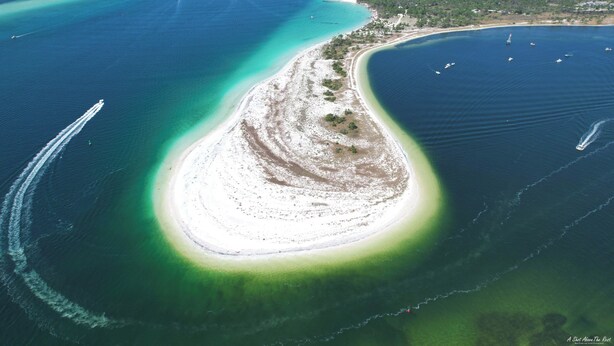 An aerial view of a coastal area with a large sandy beach, clear blue waters, and boats. - FREE Daily Golf! Reflections 406 Amazing Views, Heated Resort Pool & Hot Tub! (Panama City)