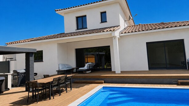 Ein zweistöckiges Haus mit Swimmingpool, Sitzgelegenheiten im Freien und einem Grillbereich.