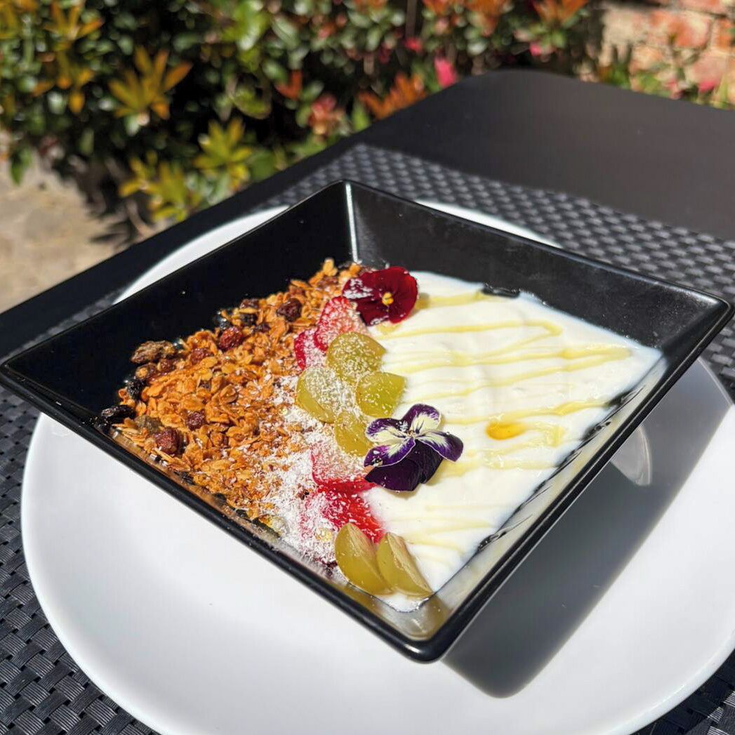 A dessert on a square plate with a textured table surface.