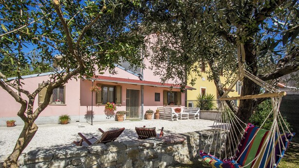 A house with a stone wall, a hammock, and outdoor seating. - LA PERLA D'ABRUZZO (Cugnoli)