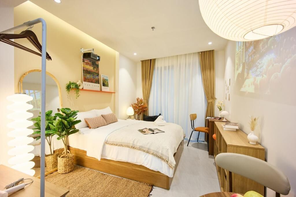 A bedroom with a bed, bedside table, lamp, and a large mirror.