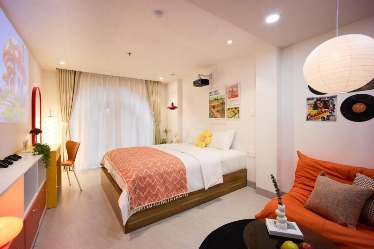 Una habitación de hotel moderna con una cama, un sofá, un escritorio y una silla.