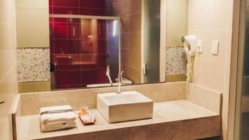 A modern bathroom with a large mirror, two sinks, and a towel rack.