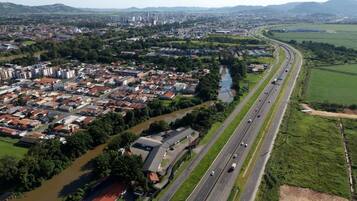 An aerial view of a city with a river running alongside a highway.