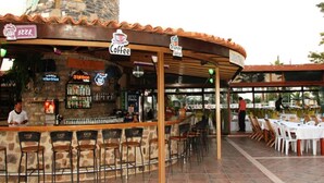 Eine Bar mit einer Steinaußenfassade, einem Schild für Kaffee und einem Schild für Bier.