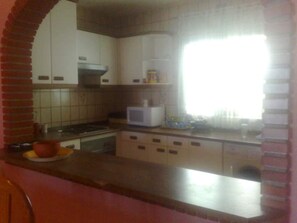 A kitchen with white cabinets, a microwave, and a brick oven. - Amazing Villa with outstanding Sea views. Near from all amenities (Benalmadena)
