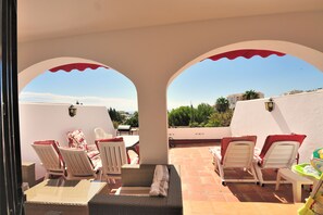 A terrace with white and red lounge chairs, a wicker sofa, and a small table. - Amazing Villa with outstanding Sea views. Near from all amenities (Benalmadena)