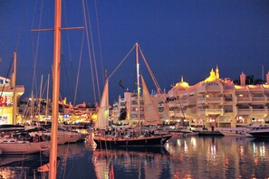 A marina with multiple boats docked, buildings with balconies, and a nighttime setting. - Amazing Villa with outstanding Sea views. Near from all amenities (Benalmadena)
