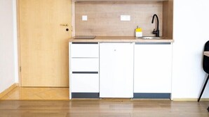 A kitchen with white cabinets, a wooden countertop, and a black faucet. - Apartments Amare / Apartment 3 with Sea view (Neum)