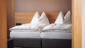 Un dormitorio con cama, cabecera de madera y piso alfombrado.