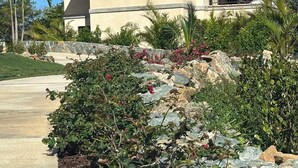 A two-story house with a tiled roof, a balcony, and a stone wall. - New 1-Bedroom villa with plunge pool on St John's amazing North Shore. (St John)