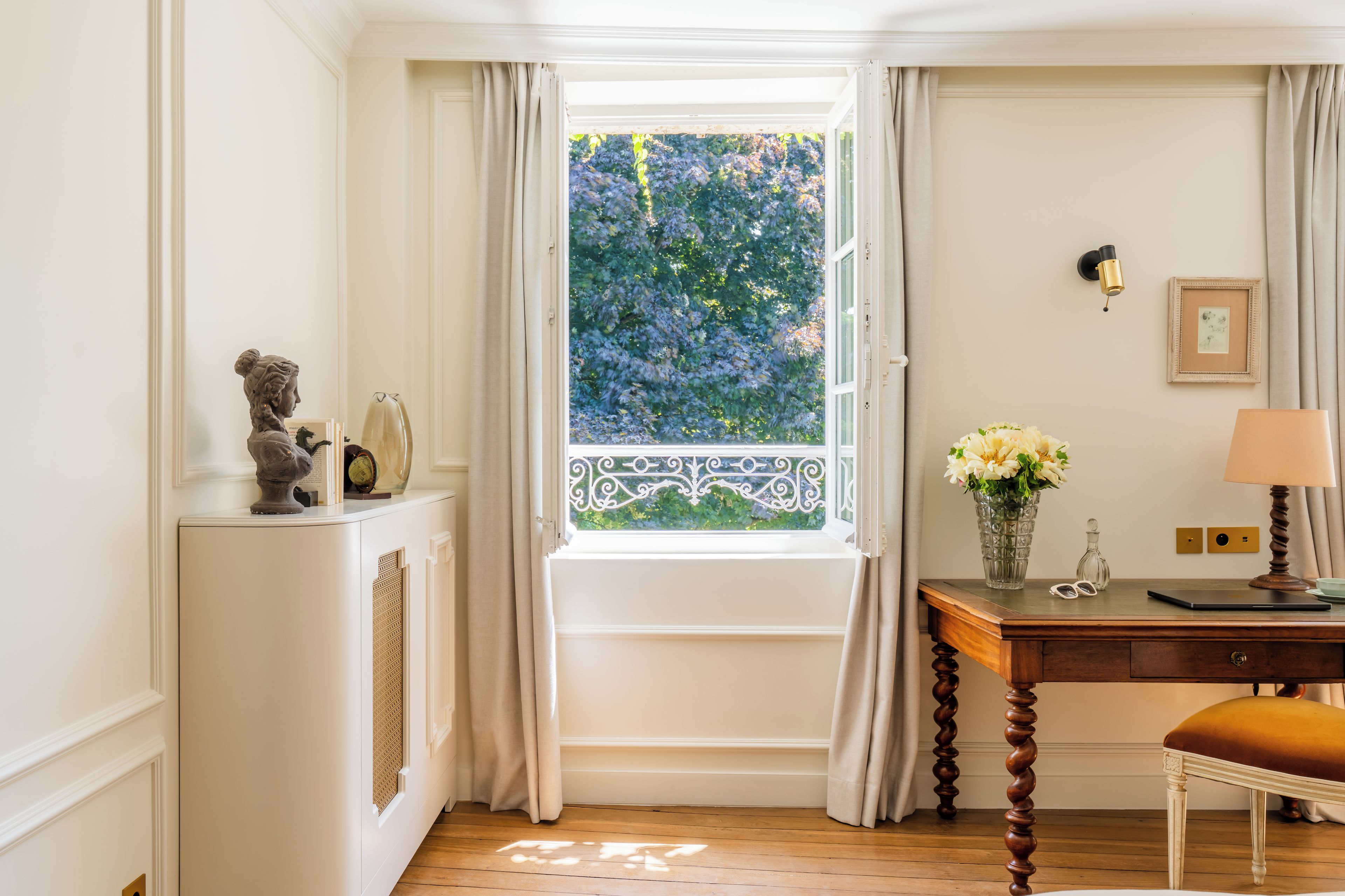 A room with a window, a desk, a chair, and a lamp.