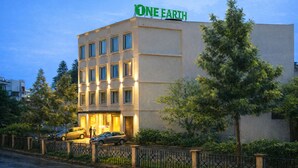 A building with 'ONE EARTH' signage, multiple windows, and a gated entrance. - One Earth Heritage Katra (Katra)