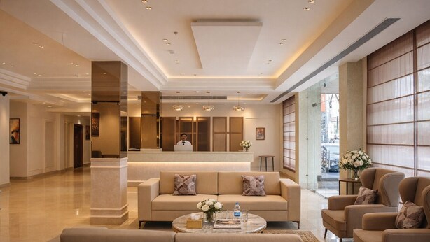 A spacious lobby with a reception desk, seating area, and large windows. - One Earth Heritage Katra (Katra)