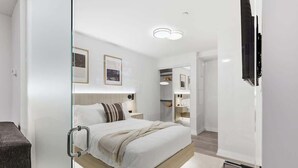Ein modernes Hotelzimmer mit Glastrennwand, einem Bett mit Holzrahmen, einem Nachttisch mit Lampe und einem an der Wand befestigten Flachbildfernseher.