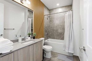 Une salle de bain moderne avec une baignoire, des toilettes et un lavabo.