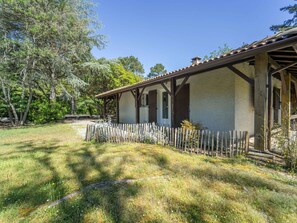 A rustic building with a covered porch, surrounded by a natural landscape. - Cosy house between forest and beach - 6 guests (Lit-et-Mixe)