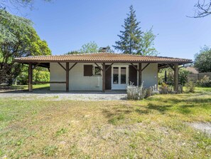 A single-story building with a tiled roof, a covered porch, and a gravel driveway. - Cosy house between forest and beach - 6 guests (Lit-et-Mixe)