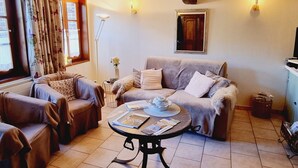 A cozy living room with a sofa, armchairs, a coffee table, and a fireplace. - Charming house, pets welcome - 4 guests (PREMONT)