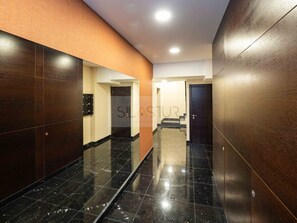 A corridor with dark wooden walls, a marble floor, and a door at the end. - Bright penthouse in city centre - 4 guests (Granada)
