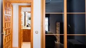 Ein Zimmer mit einem hölzernen Kleiderschrank, einem Bett und einem Schreibtisch.