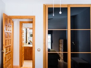 A room with a wooden wardrobe, a bed, and a desk. - Bright penthouse in city centre - 4 guests (Granada)