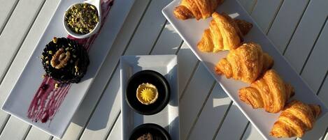Ein weißer Tisch mit einem Streifenmuster, ein weißer Teller mit Gebäck und ein weißer Teller mit Desserts.