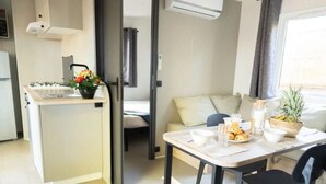 Un espacio habitable compacto con kitchenette, comedor y sofá.