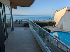 A balcony with a view of the sea, a swimming pool, and a private area sign. - Pleasant apartment sea view - 4 guests (Menton)