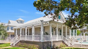 A two-story house with a covered porch, a swimming pool, and a well-maintained lawn. - New! Private Pool -Free Golf Cart -Block to Beach -Fully Updated -Crystal Beach (Destin)