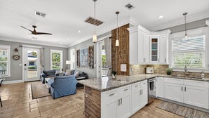 A modern kitchen with white cabinets, a granite countertop, and a built-in oven. - New! Private Pool -Free Golf Cart -Block to Beach -Fully Updated -Crystal Beach (Destin)