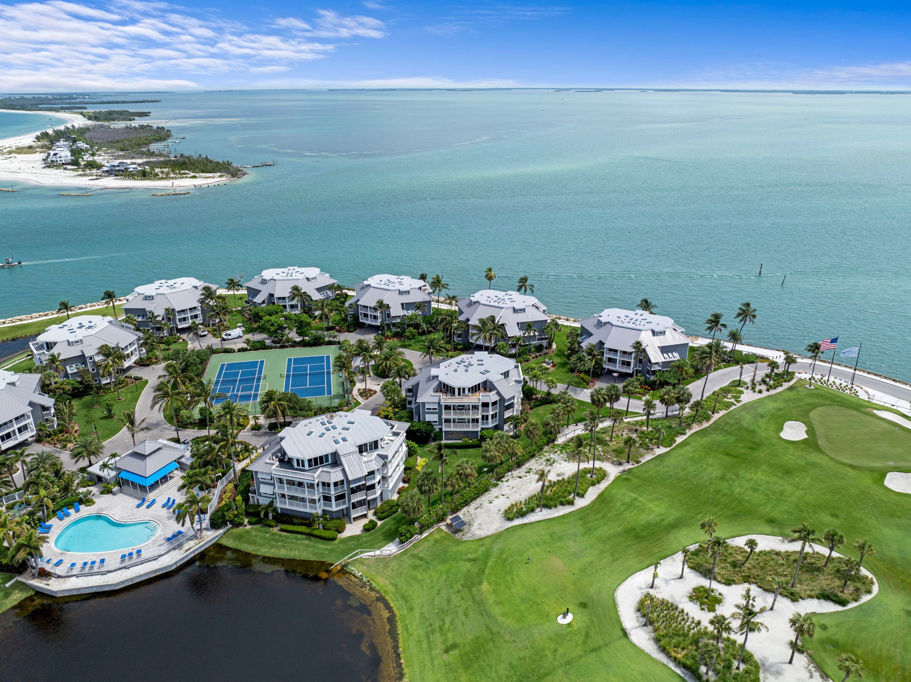 Een resort met meerdere gebouwen, een tennisbaan, een zwembad en een golfbaan.