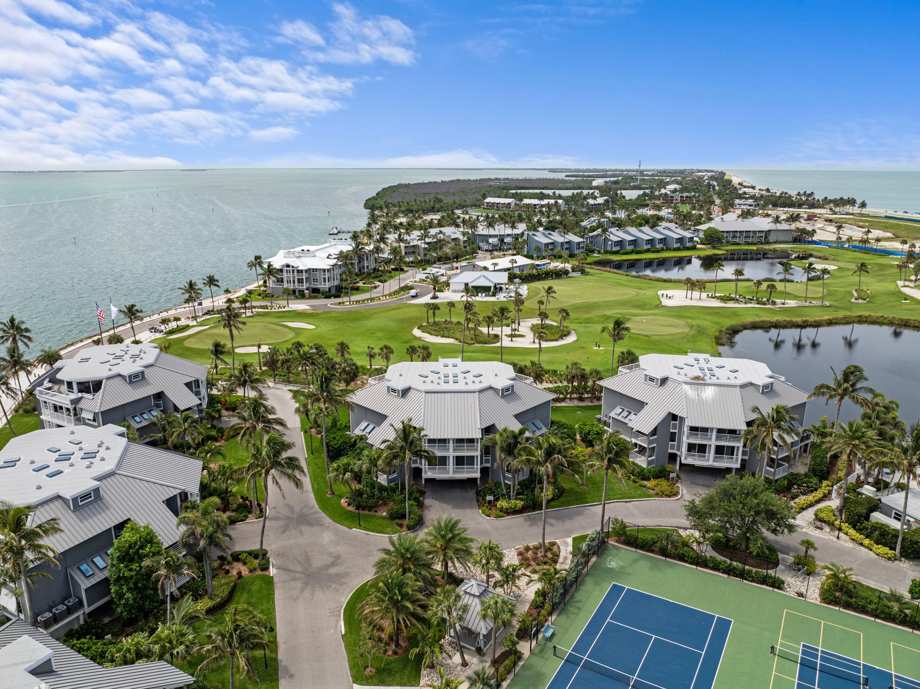 Um resort com vários edifícios, um campo de golfe e uma praia.