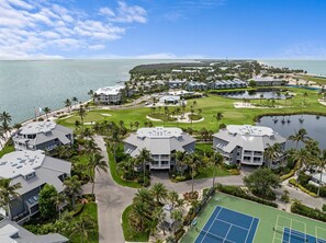 Um resort com vários edifícios, um campo de golfe e uma praia.