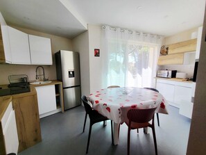 A compact kitchen with a dining area, a refrigerator, a microwave, and a sink. - T4 all comfort - walking distance to the beach 2 swimming pools (Linguizzetta)